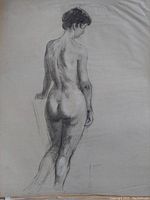 Close-up photo of a charcoal or graphite life drawing depicting a nude female figure from the back, showing detail and shading.