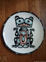 Top view of ceramic plate showing the stylized Tlingit bear design in turquoise, black, white, and brown colors.