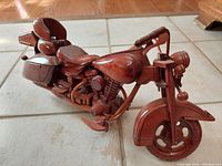 Side front view showing the detailed front wheel, headlamp, and handlebars of the hardwood motorcycle model.