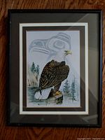 Front view of framed watercolor painting titled 'The Eagle' by Sue Coleman showing a bald eagle with a Haida totem design and natural landscape elements.