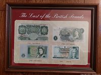 Frontal image showing the entire wood framed display under glass with the title 'The Last of the British Pounds' and four British one pound notes.