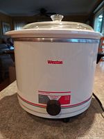 Full view of Weston crockery cooker showing white body with red Weston branding, glass lid, and overall size of unit.