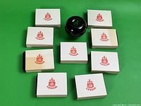 Nine closed white cardboard sleeves with red Canada crest and green glass apple size reference.