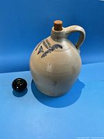 Front three-quarter view of the jug showing overall shape, handle, cork stopper and decoration