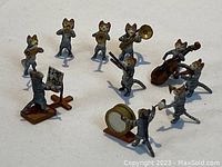Group overview of all 11 miniature cat band figurines arranged on white background