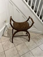Front view of antique walnut half-moon chair showing curved legs, armrests, and brown floral velvet upholstered seat.