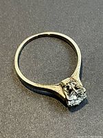Angled top view showing round diamond and 14K gold solitaire setting
