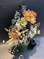 Overall view of jade stone tree with colored flowers in cloisonné pot, with green glass apple reference