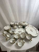 Wide view of all porcelain pieces on table showing teacups, saucers, bowls and platters