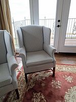 Front view of a single armchair showing upholstery pattern and frame detail