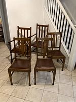 Six oak dining chairs arranged in two rows, front view