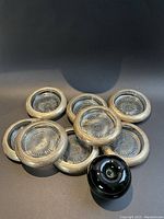 Eight sterling silver rimmed glass coasters arranged in a group, showing the overall quantity and condition.