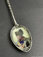 Close-up photo showing enameled portrait of Napoleon on the bowl of the teaspoon, highlighting detailed silverwork and colors.