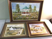 Three framed paintings displayed together on the floor showing the overall lot contents