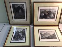 Four framed lithographs laid out on table showing scenic water views and one of the Melrose Abbey gates
