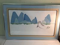 Framed harbor seal print with stylized PNW ocean rocks visible on wall
