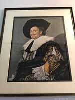 Full view of the framed musketeer print, showing the entire artwork and frame with ornate costume and ruff collar visible.