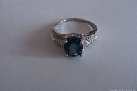 Front view of the ring showing the large oval London Blue Topaz center stone and diamond accented shoulders.