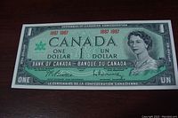 Front side of the 1967 Canadian Centennial one dollar bill showing Queen Elizabeth II and centennial dates 1867 1967.