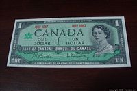 Front side of the 1967 Canadian Centennial one dollar bill showing Queen Elizabeth II and centennial markings.