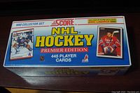 Front angled view of the box showing '1990 Collector Set SCORE NHL Hockey Premier Edition 445 Player Cards' with an Eric Lindros exclusive card image and other player images on the packaging.