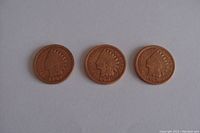 Front (obverse) side of three Indian Head pennies dated 1902, 1905, and 1907 showing the Native American profile with feathered headdress.