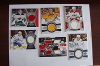 Front side of 6 NHL jersey cards showing player images and embedded fabric patches of jerseys.