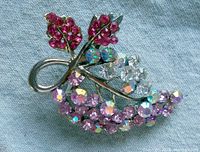 Front view of the vintage brooch showing detailed Aurora Borealis rhinestones in multiple colors arranged in a floral leaf pattern on silver-tone metal.