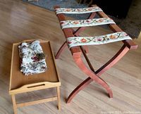 Photo showing the wooden folding bed tray with fabric table runner on top, alongside the folding luggage stand with embroidered straps.