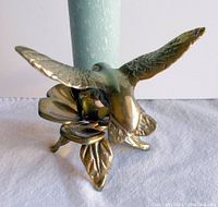 Front angled view showing hummingbird and candle with flower petals and leaves as base
