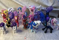 Front and top view of 16 assorted My Little Pony toys including winged and horned ponies in various colors.