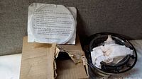 Original worn shipping box with damages shown next to lamp dome and packing paper.