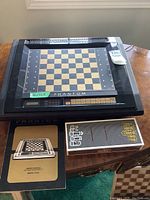 Front view showing electronic chess board, instruction manual and small accessory box