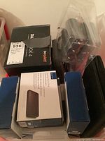 Photo showing six items including the be quiet! cooling fan, and multiple Insignia hard drive enclosures in original packaging.
