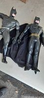 Two 12-inch Batman superhero action figures laid side by side, showing overall size and costume details.