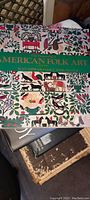 Cover photo of The Reverend American Folk Art book showing colorful folk art style illustrations and title in green band. The book is hardcover and in very good condition.