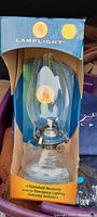 Front view of the unused Lamplight oil lamp inside original box, showing glass chimney and metal components.