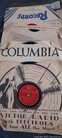 Close-up photo of a Columbia label 78 RPM record in its original paper sleeve showing vintage illustration and wear.