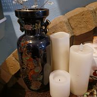 Dark blue ceramic vase with detailed colorful crane bird artwork and floral patterns, viewed in natural room setting