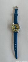 Full length view of the Smurf watch with blue strap laid flat.