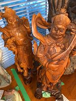 Both carved wooden figurines front view on tabletop