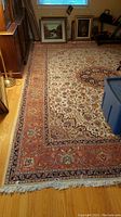 Full view of rug on hardwood floor showing overall pattern and fringe