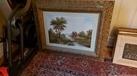 Overview of two framed prints leaning against wall on rug