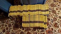 Two rows of yellow‐spined Nancy Drew hardcovers arranged on patterned rug