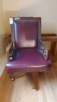 Front view of wood framed office chair with burgundy leather look seat and backrest, nailhead detailing visible.