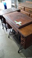 Full view of wood sewing table showing foldable top and drawer, with metal legs.