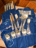 Full view of all cutlery pieces laid out in blue cloth roll