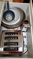Top view of all items including the Oster toaster, can opener, bowls and platter inside a drawer