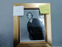 Framed black and white photograph of Matthew McConaughey with signature across the front, positioned on a table with labels noting '31' and 'Matthew McConaughey (actor)'