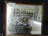 Rectangular mirror sign with Teacher's Highland Cream Scotch Whisky branding and decorative engravings in gold and black.